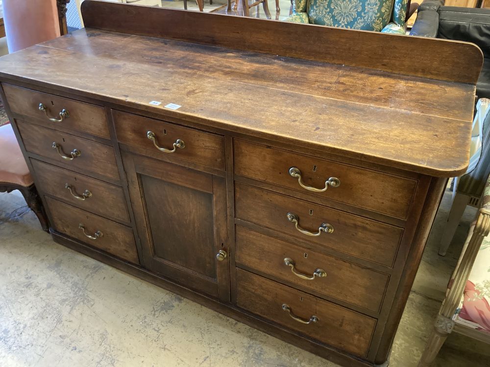 A late George III mahogany low dresser, fitted nine small drawers, about a central cupboard, width 166cm, depth 58cm, height 102cm